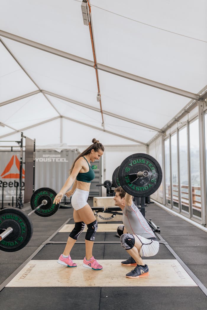 about-img-02 Dynamic weightlifting session with a couple in a modern indoor gym setting.